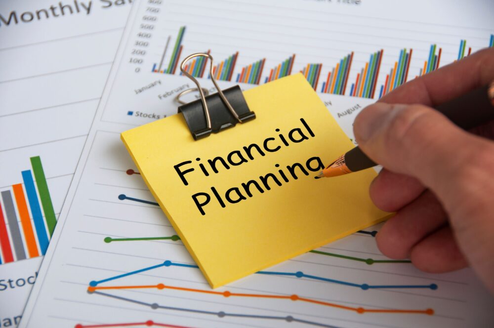 This image has an empty alt attribute; its file name is financial-planning-text-yellow-notepad-with-financial-data-analysis-background-financial-planning-concept-1-scaled-3.jpg